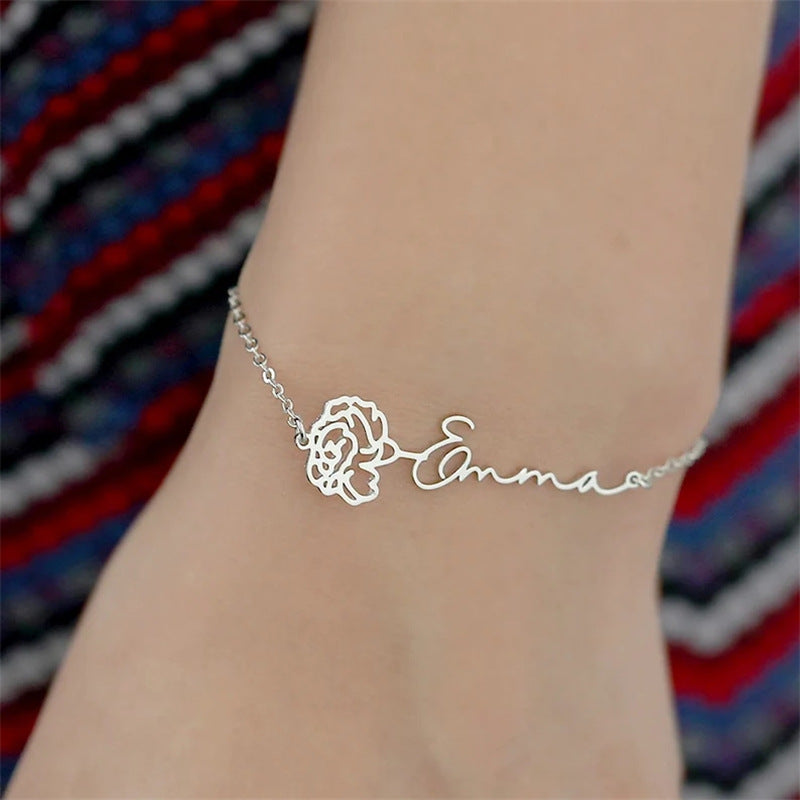 Custom name bracelet featuring a delicate rose charm.
