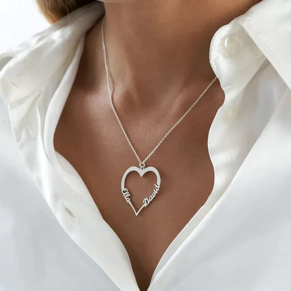 "Heart-shaped pendant with names and gem."
